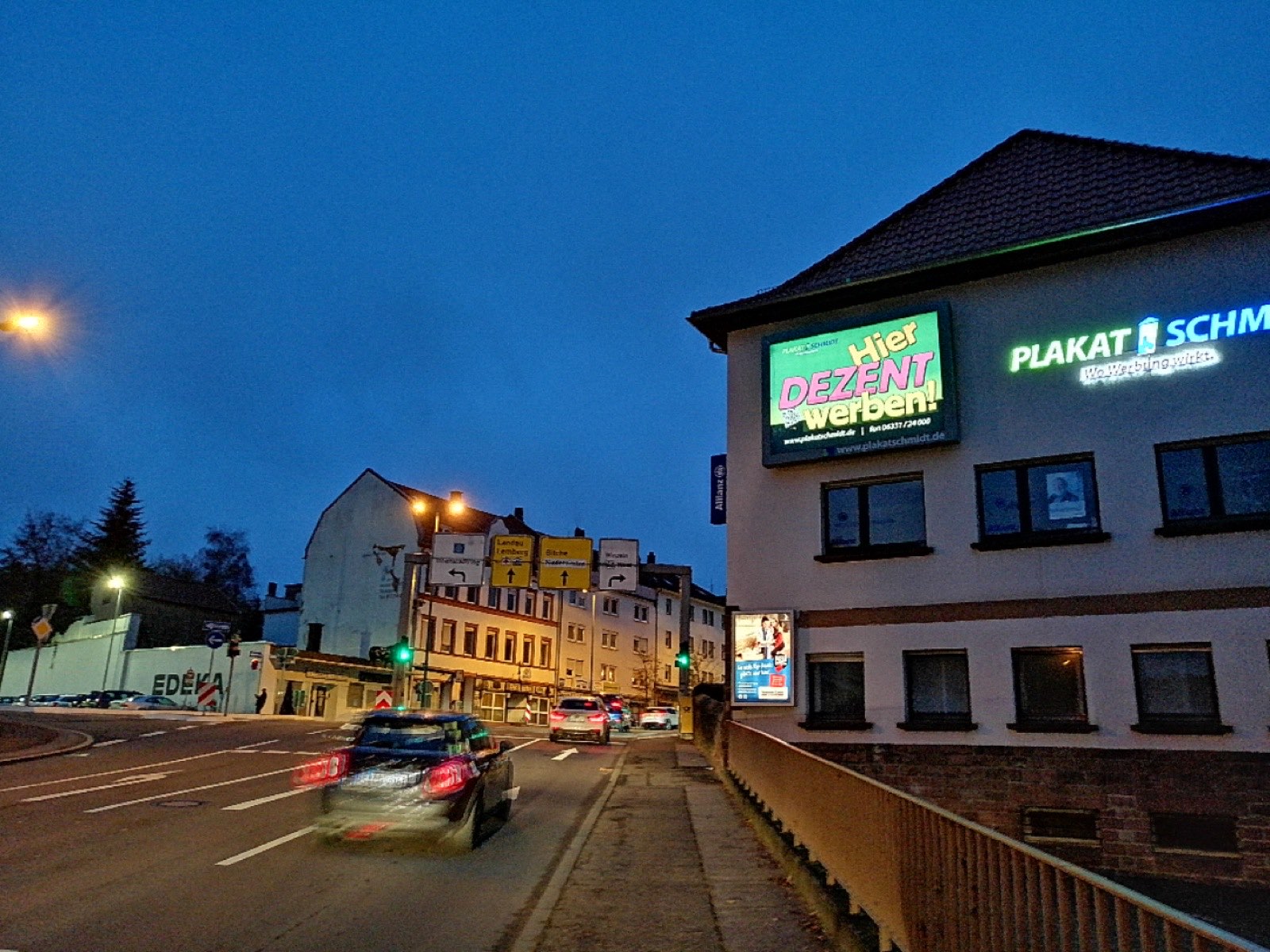 Firmensitz von Plakatschmidt in Pirmasens bei Nacht mit leuchtendem LED-Board und Leuchtreklame